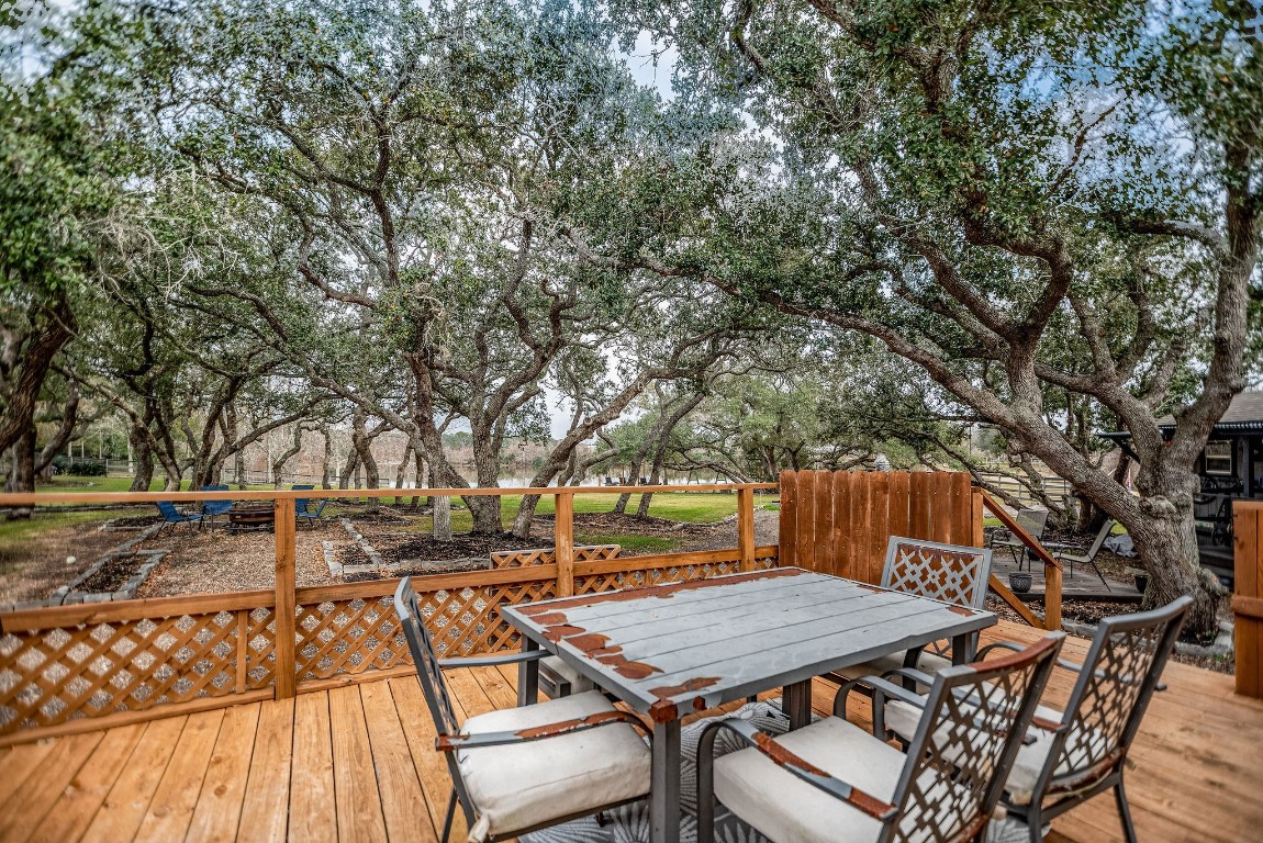1236 Riverside Drive Palacios, TX 77465 - Photo 19 of 35 a view of a patio with table and chairs with wooden floor and fence