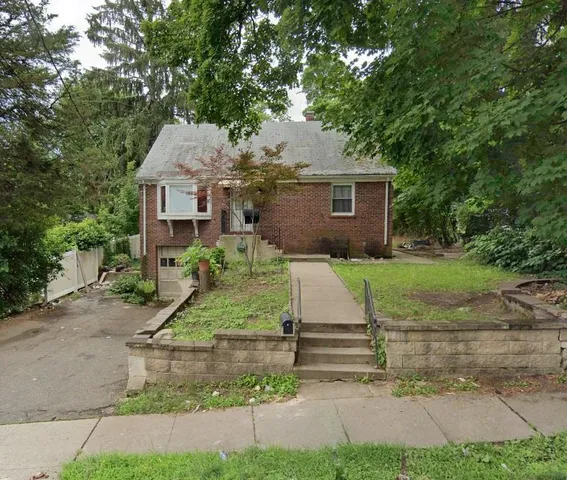 a view of a yard in front of a house with large tree