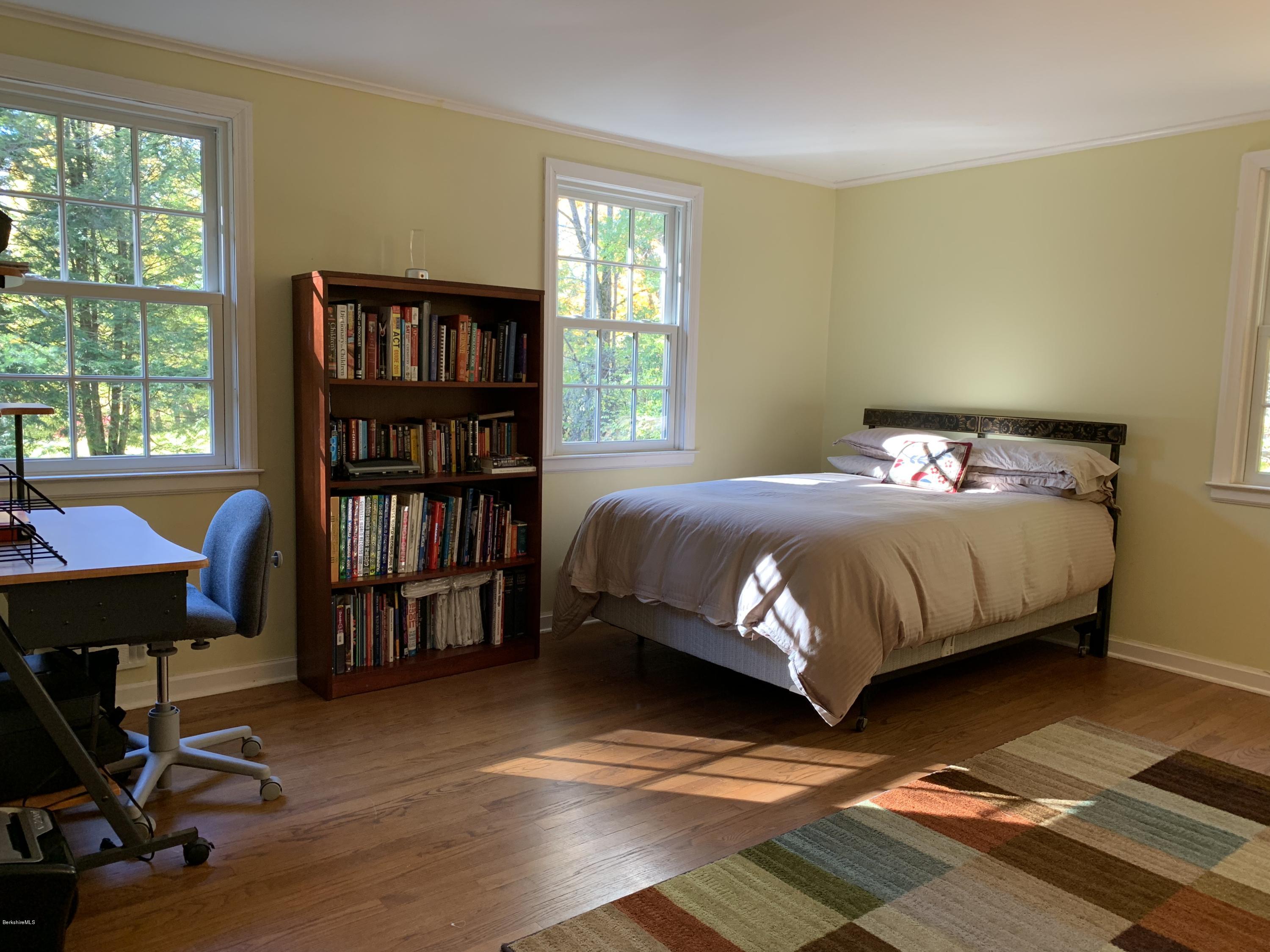 261 Old Stockbridge Road Lenox, MA 01240 - Photo 22 of 43 a bedroom with a bed a bookshelf and a bookshelf