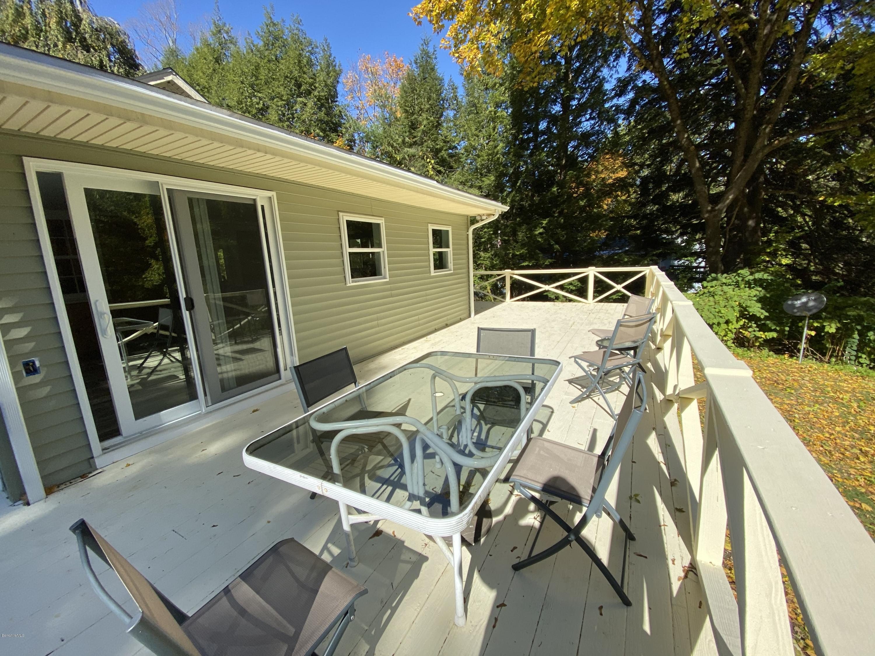 261 Old Stockbridge Road Lenox, MA 01240 - Photo 37 of 43 a view of a patio with table and chairs with wooden floor and fence