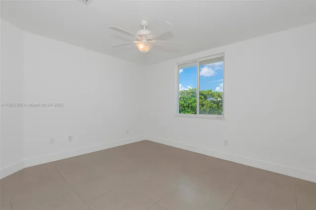 an empty room with a ceiling fan and a window