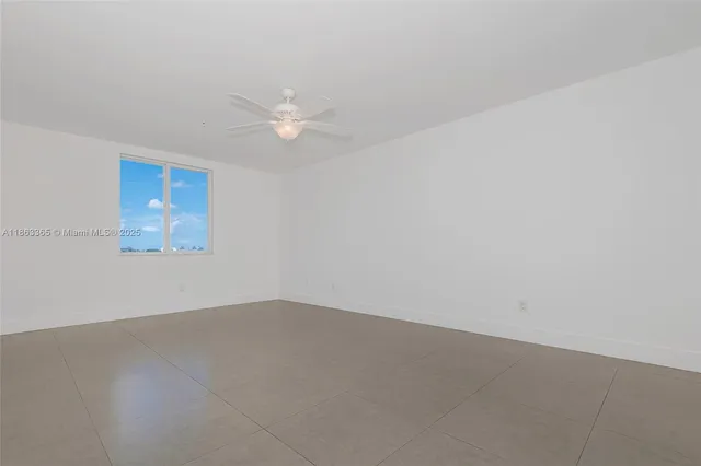 an empty room with an entryway and fan