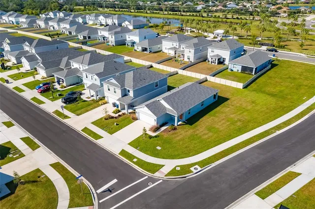 an aerial view of a swimming pool with outdoor seating