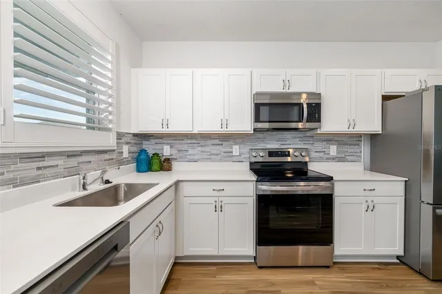 a kitchen with a sink stove and microwave