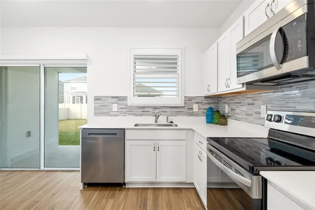 a kitchen with stainless steel appliances granite countertop a stove a sink and a microwave