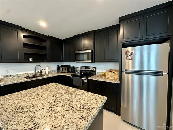a kitchen with a refrigerator and a stove top oven