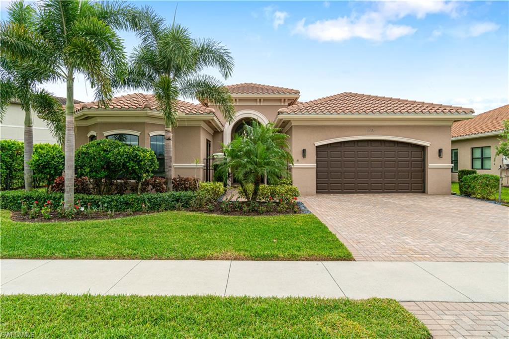 4427 Caldera Circle Naples, FL 34119 - Photo 1 of 50 a front view of a house with a garden and garage