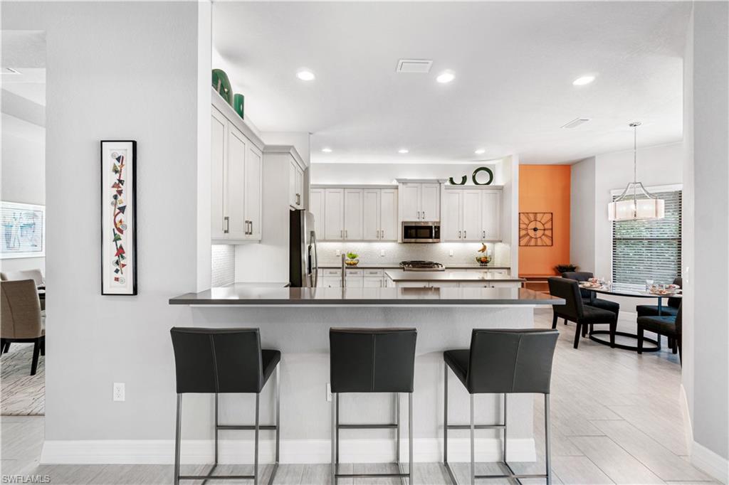 4427 Caldera Circle Naples, FL 34119 - Photo 14 of 50 a large kitchen with lots of counter space and chairs