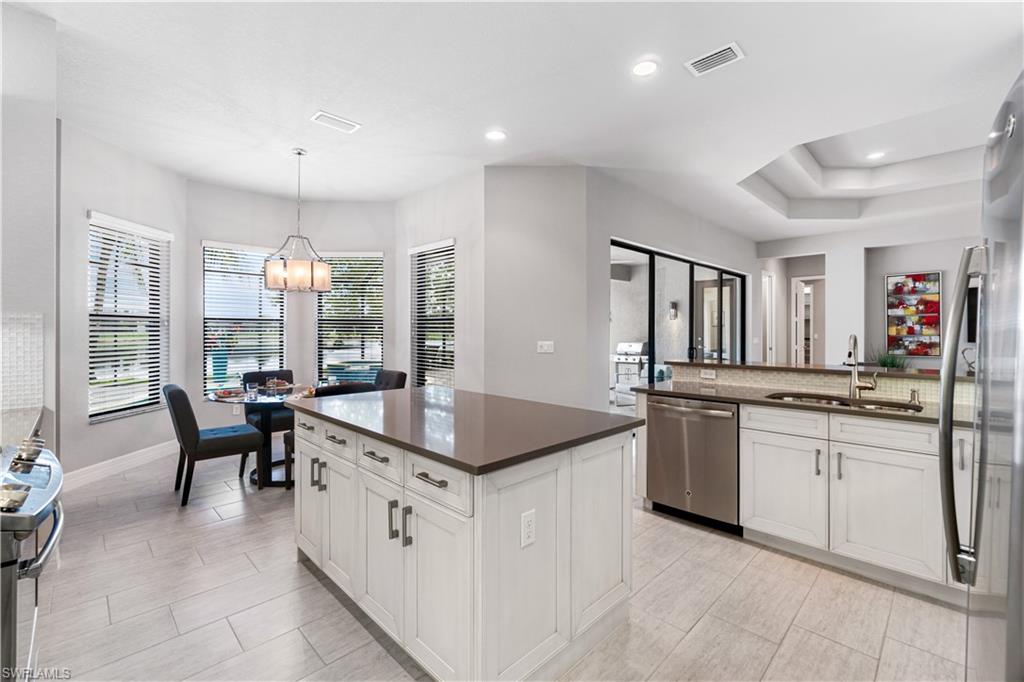 4427 Caldera Circle Naples, FL 34119 - Photo 19 of 50 a large kitchen with granite countertop a sink and white cabinets