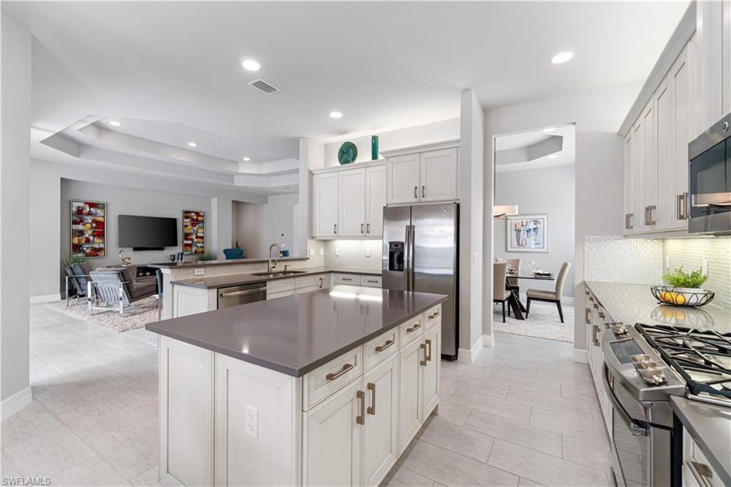 4427 Caldera Circle Naples, FL 34119 - Photo 20 of 50 a kitchen with stainless steel appliances granite countertop a sink stove and refrigerator