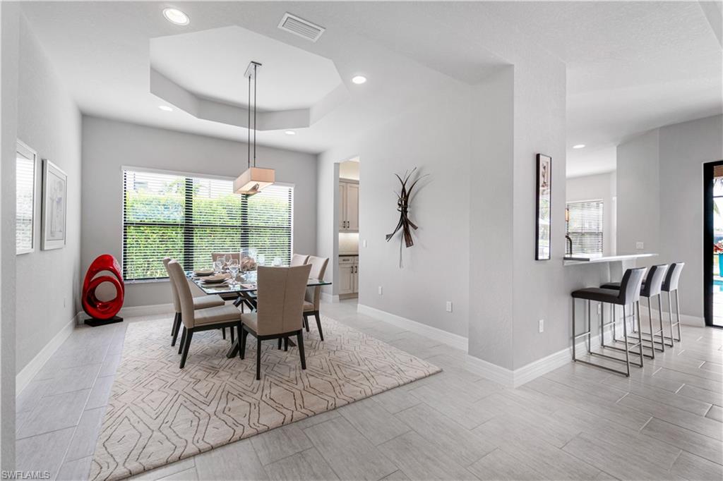 4427 Caldera Circle Naples, FL 34119 - Photo 22 of 50 a dining room with furniture a chandelier and wooden floor