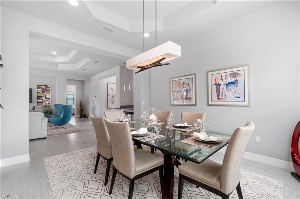 4427 Caldera Circle Naples, FL 34119 - Photo 25 of 50 a dining room with furniture a rug and wooden floor