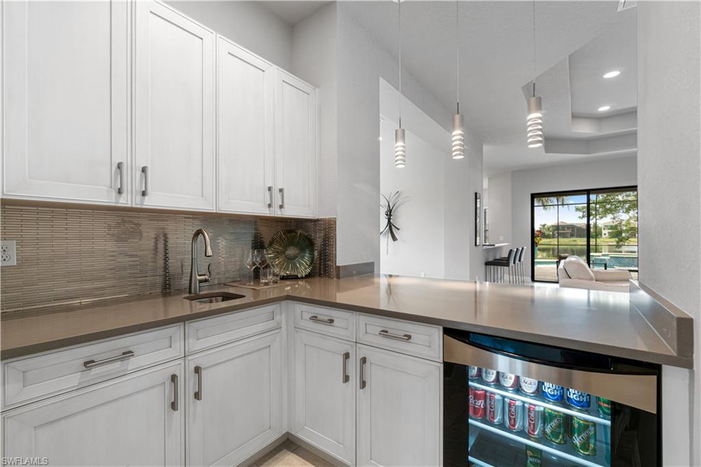4427 Caldera Circle Naples, FL 34119 - Photo 29 of 50 a kitchen with stainless steel appliances granite countertop a stove a sink and white cabinets