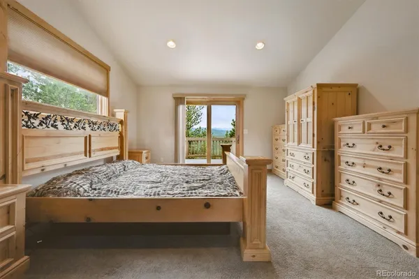 a bedroom with a bed and large windows