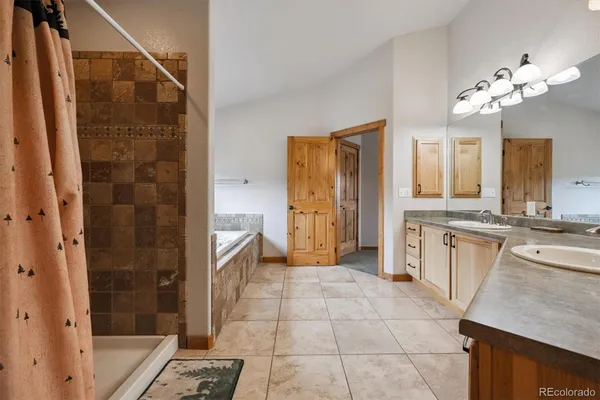 a bathroom with a granite countertop sink a mirror and a bathtub
