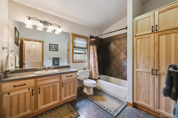 a bathroom with a double vanity sink toilet mirror and shower