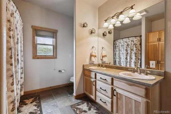 a spacious bathroom with a double vanity sink a mirror a and a shower
