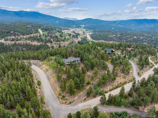an aerial view of residential houses with outdoor space and trees