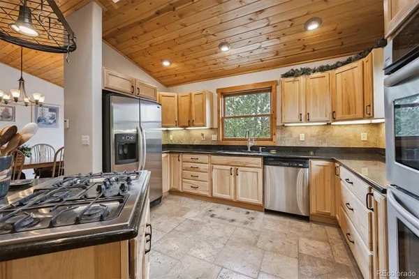 a kitchen with stainless steel appliances granite countertop a stove sink and cabinets