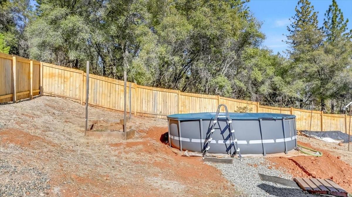 Undisclosed Address Grass Valley, CA 95949 - Photo 26 of 26 a view of a backyard with a large tree and wooden fence