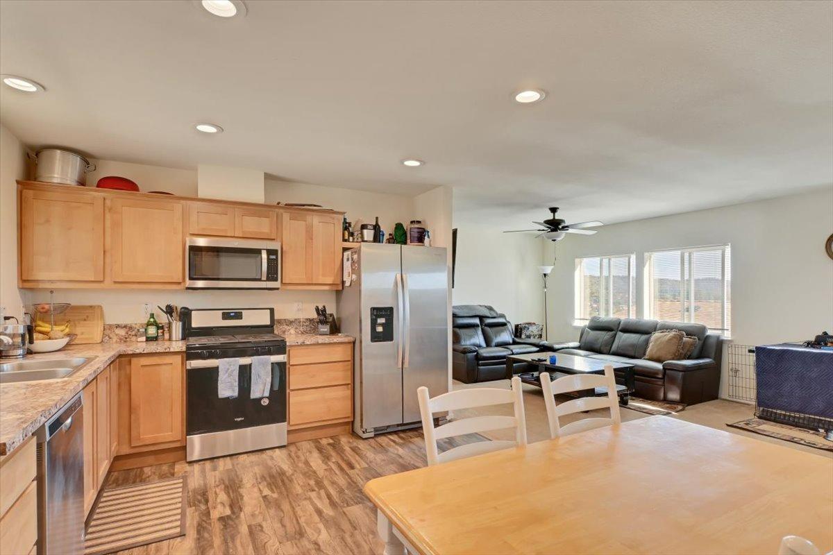 Undisclosed Address Grass Valley, CA 95949 - Photo 6 of 26 a kitchen with stainless steel appliances granite countertop a refrigerator a stove a sink dishwasher a dining table and chairs with wooden floor