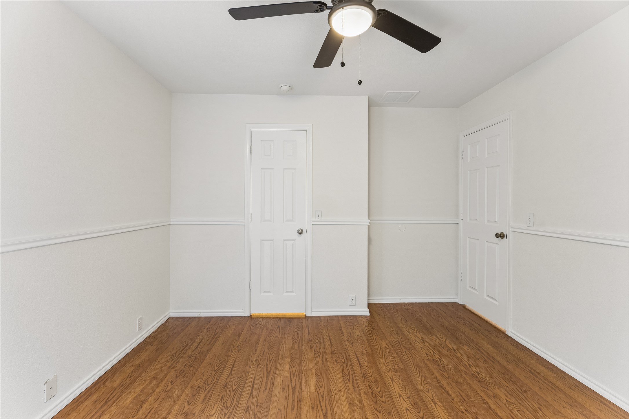 2372 Paradise Ridge Drive Round Rock, TX 78665 - Photo 36 of 40 A comfortable bedroom with rich wood flooring and a modern ceiling fan.