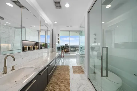 a large white kitchen with a large window and stainless steel appliances