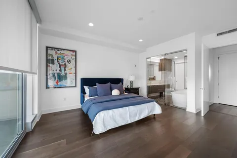a bedroom with a large bed and a wooden floor