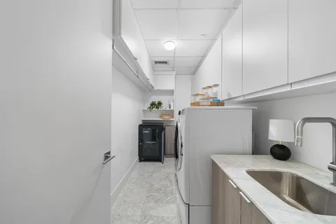 a kitchen with a sink a refrigerator and cabinets