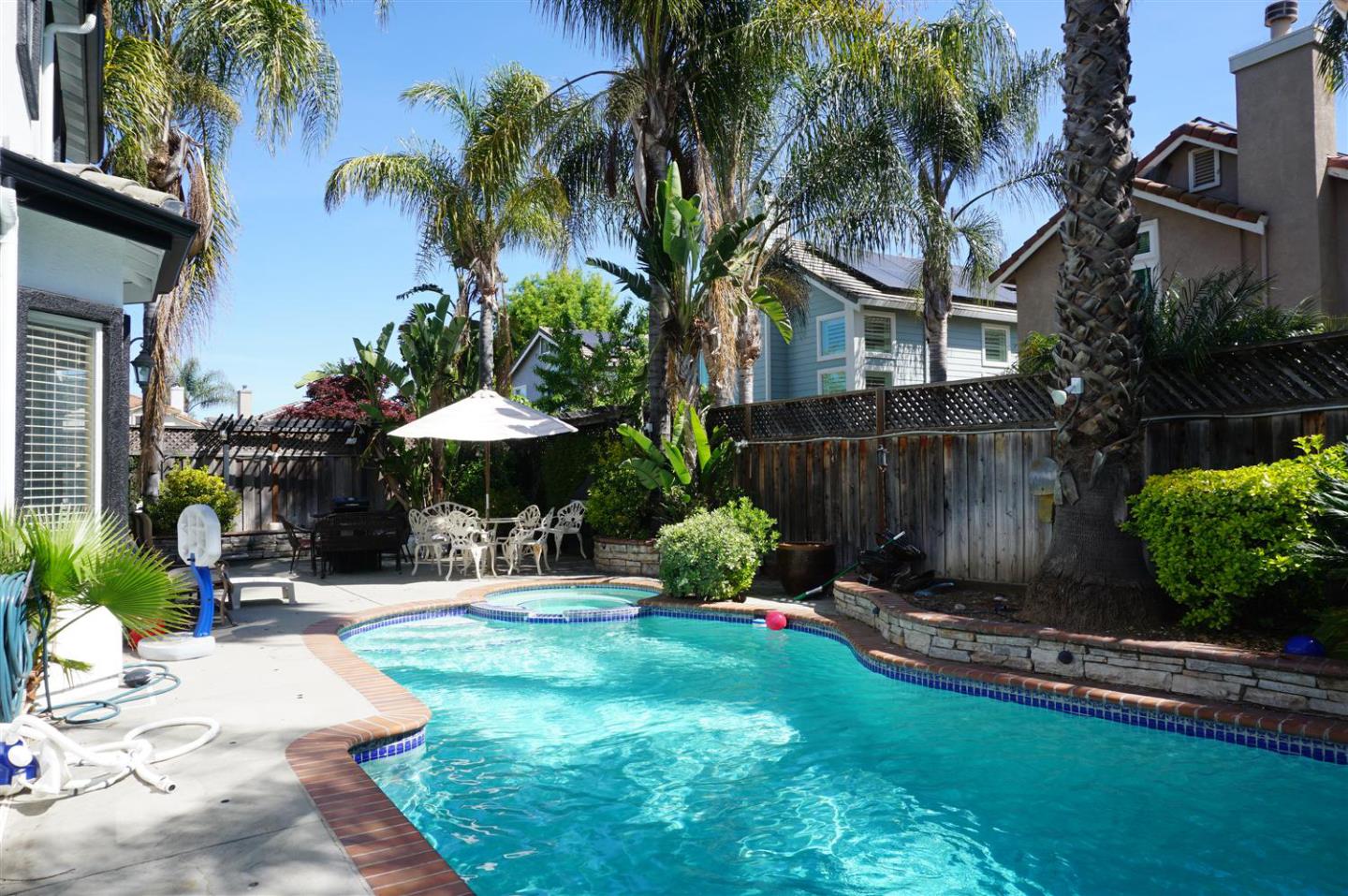9402 Rodeo Drive Gilroy, CA 95020 - Photo 18 of 22 a view of a backyard with a table and chairs under an umbrella