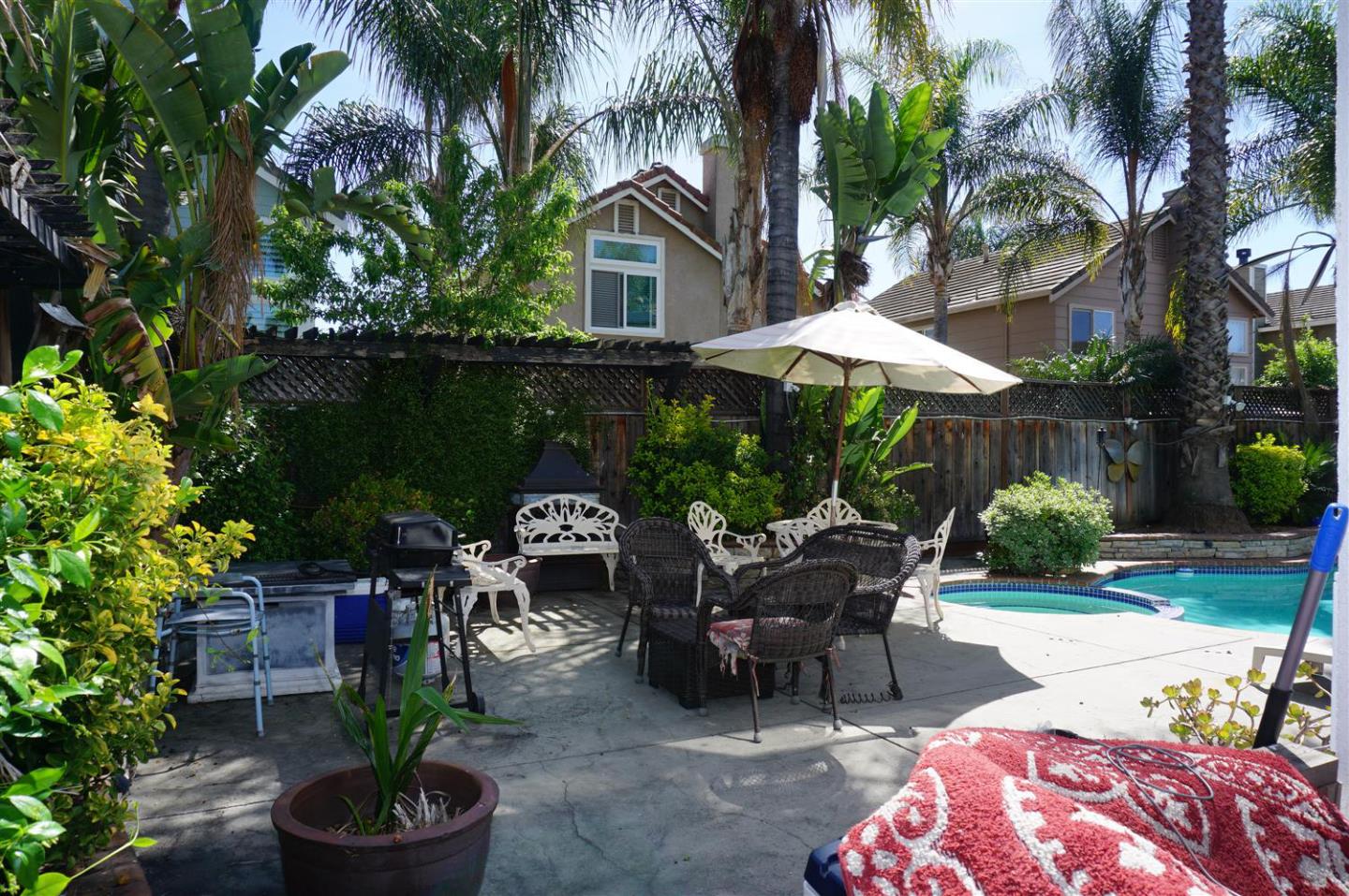9402 Rodeo Drive Gilroy, CA 95020 - Photo 21 of 22 a view of a patio with table and chairs potted plants and palm tree