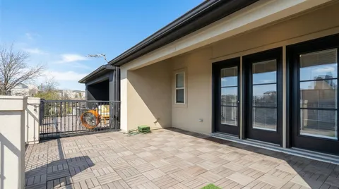 a view of a balcony with a barbeque and wooden stairs