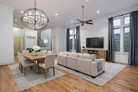 a living room with furniture a chandelier and a flat screen tv