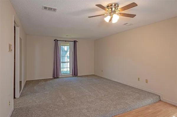 a view of a big room with windows and chandelier fan