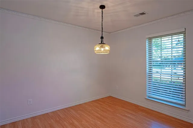 a view of a room with a window and wooden floor