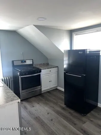 a sink with granite countertop white cabinets