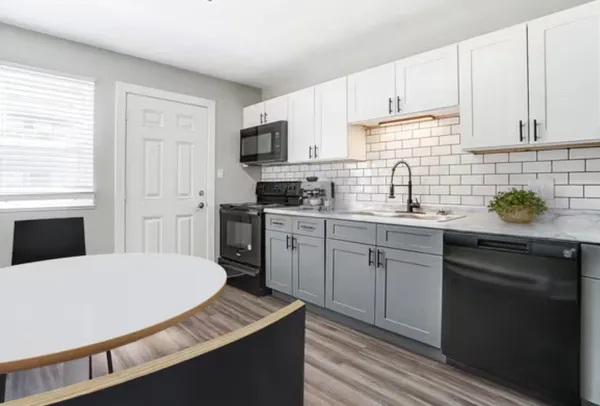 a kitchen with cabinets appliances a sink and a window