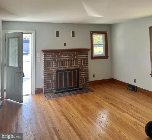 an empty room with windows and fireplace