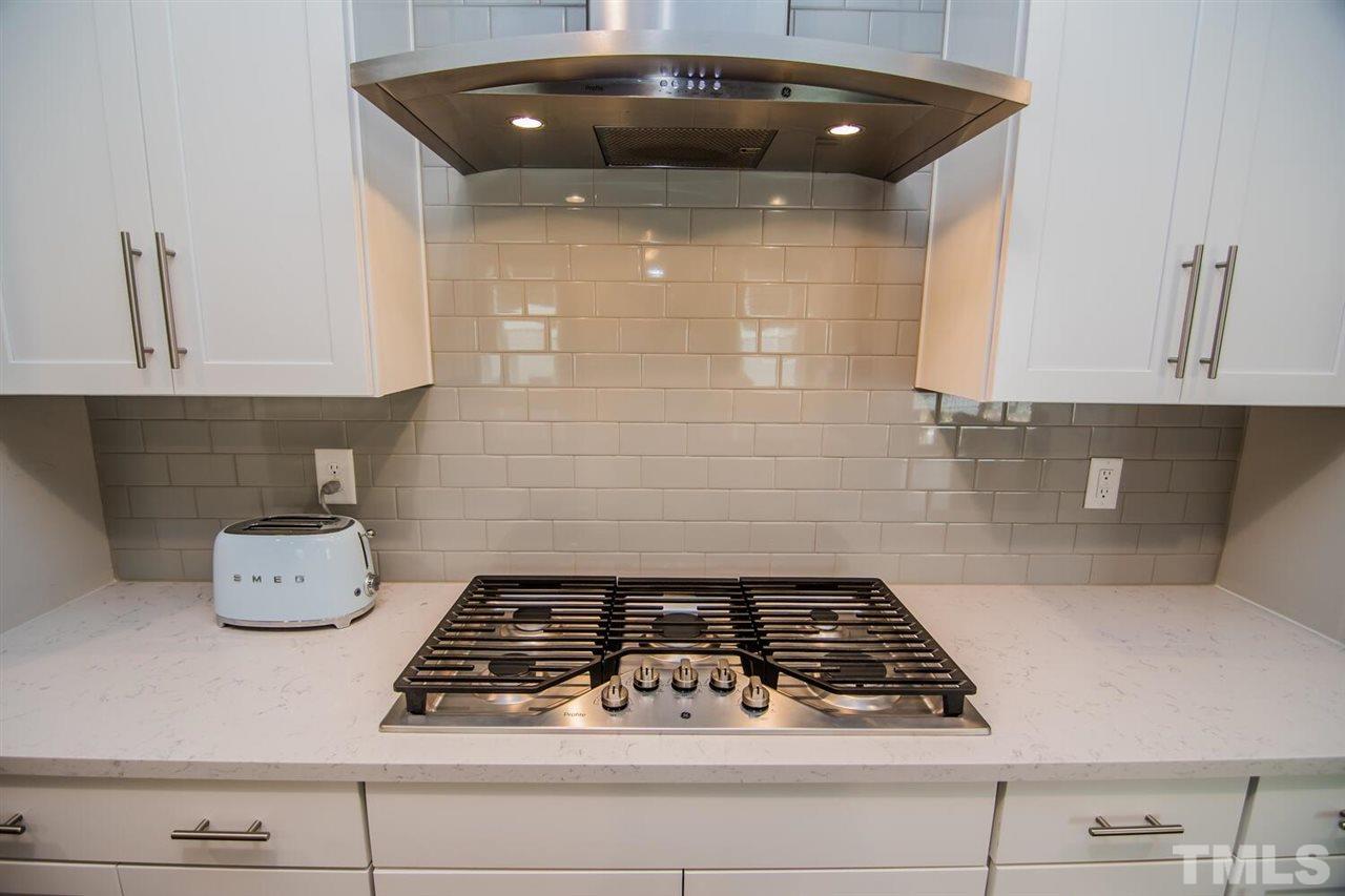1210 Pondfield Way Durham, NC 27713 - Photo 17 of 29 a kitchen with a stove and white cabinets