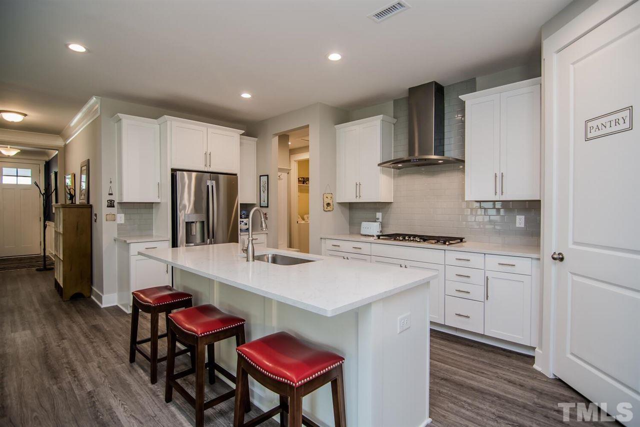 1210 Pondfield Way Durham, NC 27713 - Photo 18 of 29 a kitchen with stainless steel appliances granite countertop a refrigerator a stove a sink dishwasher and white cabinets with wooden floor