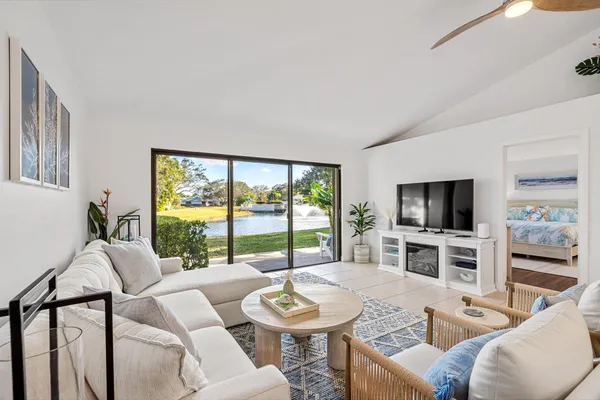 a living room with furniture a flat screen tv and a large window