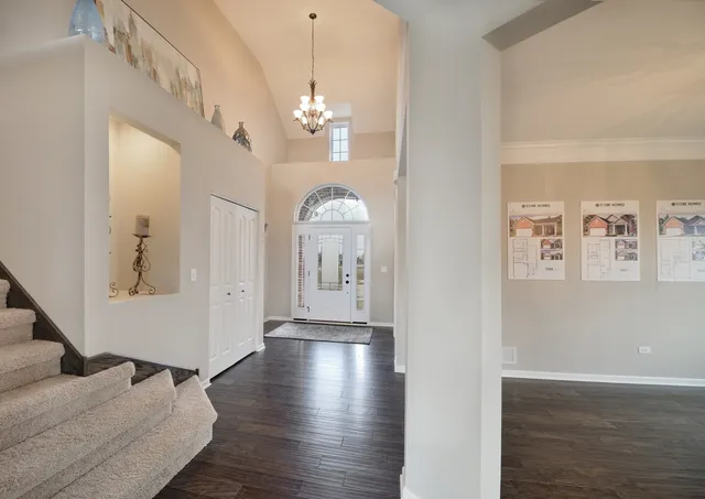 a view of a livingroom with wooden floor and kitchen view