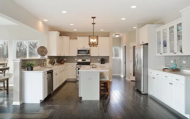 a kitchen with white cabinets and stainless steel appliances
