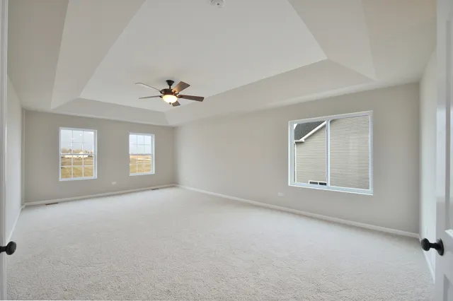 an empty room with a window and a ceiling fan