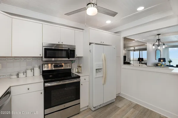a view of a dining room with furniture a chandelier and wooden floor