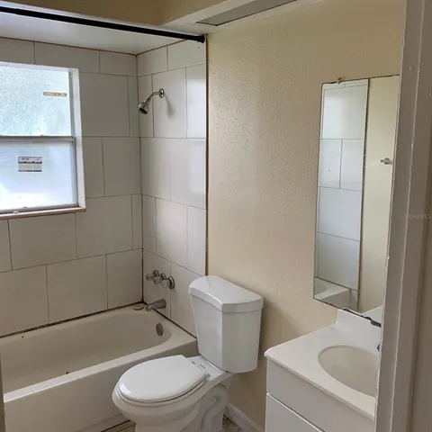 a white toilet and tub sitting next to a bathroom sink