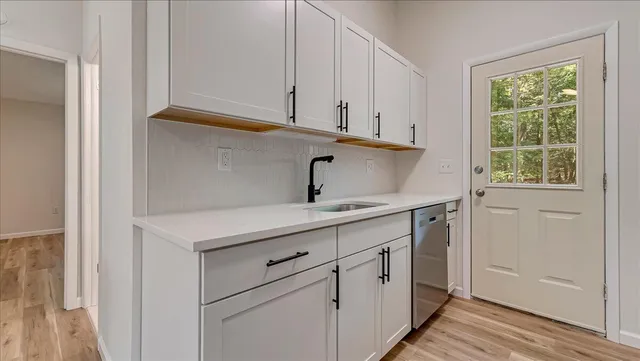 a view of a kitchen with wooden floor and a sink