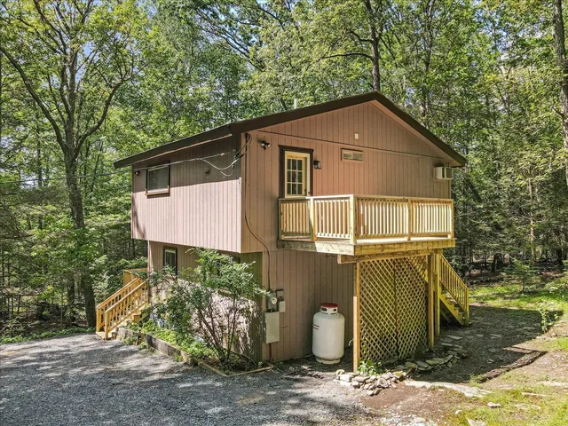 a view of an empty room with wooden floor and a large window