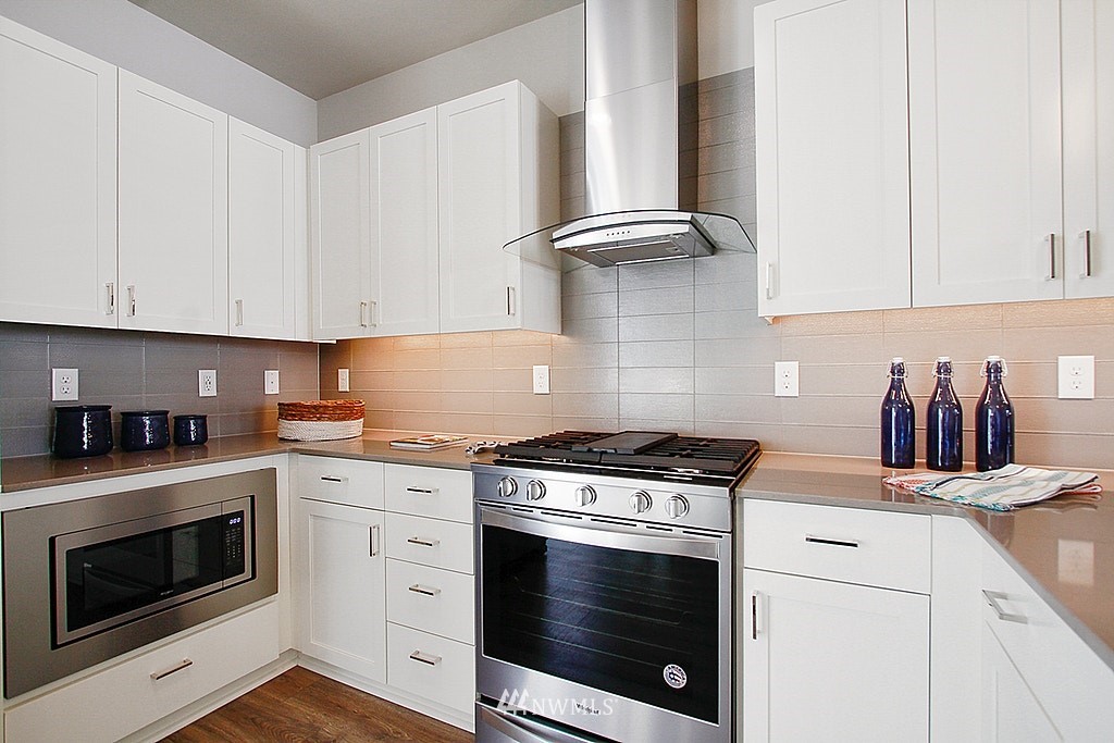 8554 22nd Place Northeast Seattle, WA 98115 - Photo 11 of 25 a kitchen with granite countertop white cabinets and white stove