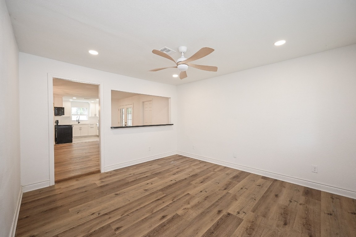11027 Maize Lane Houston, TX 77041 - Photo 3 of 32 an empty room with wooden floor and a ceiling fan